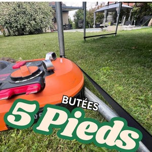 Puede incluir: Cortacésped robótico naranja y negro con un cable perimetral negro. El cortacésped tiene una superposición de texto que dice "5 Pieds Butées".