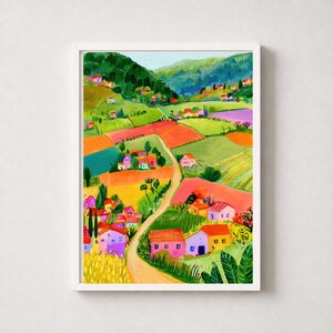 Könnte beinhalten: Ein vertikaler Kunstdruck mit einem lebendigen Landschaftsgemälde einer hügeligen Landschaft mit bunten Häusern, grünen Hügeln und Patchwork-Feldern in Gelb-, Orange-, Rosa- und Violetttönen, alles eingerahmt von einem einfachen weißen Rand.