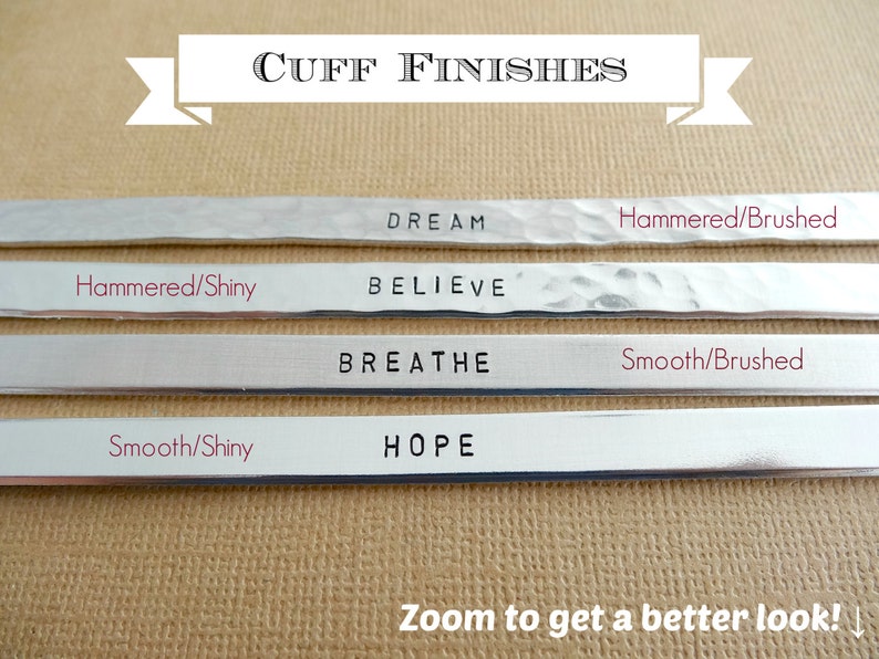 May include: Four silver metal cuff bracelets with different finishes. The top bracelet has the word "DREAM" engraved on it and is hammered with a brushed finish. The second bracelet has the word "BELIEVE" engraved on it and is hammered with a shiny finish. The third bracelet has the word "BREATHE" engraved on it and is smooth with a brushed finish. The bottom bracelet has the word "HOPE" engraved on it and is smooth with a shiny finish.
