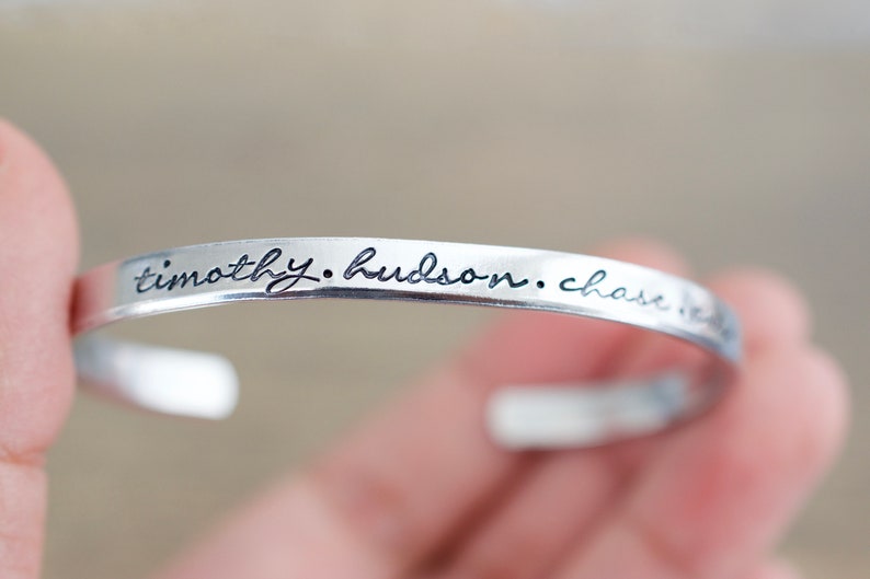 May include: Silver bracelet with the inscription "timothy. hudson. chase. love."