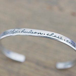 May include: Silver bangle bracelet with the inscription "faithfully. hudson. chase. crew" engraved on the band.