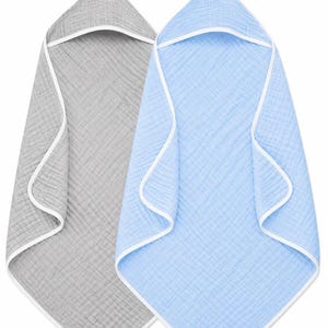 May include: Two hooded baby towels. One is light gray, the other is light blue. Both have a white trim around the edges and hood. The towels are made of a soft, textured fabric.