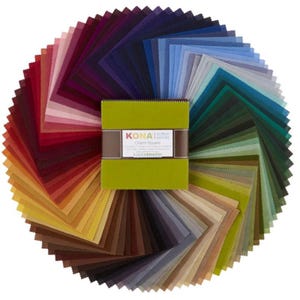 May include: A stack of square fabric swatches arranged in a circular fan pattern, featuring a wide spectrum of colors including reds, oranges, yellows, greens, blues, and purples. A lime green band labeled KONA cotton solids Charm Square wraps the center.