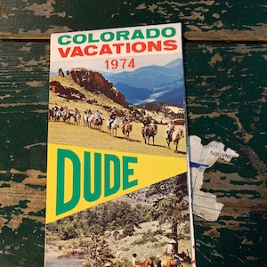May include: A vintage brochure advertising Colorado dude ranches for vacations in 1974. The cover features a scenic mountain landscape with a group of people horseback riding. The text "DUDE RANCHES" is in large green letters.