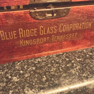 May include: A wooden box with a metal latch and the text "BLUE RIDGE GLASS CORPORATION KINGSPORT, TENNESSEE" in gold lettering.