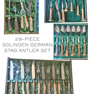 May include: A 29-piece Solingen German stag antler cutlery set. The set includes knives, forks, spoons, and serving utensils with stainless steel blades and tines. The handles are made of natural stag antler, presented in a green velvet-lined case.