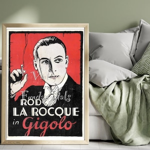 May include: A vintage movie poster with a black and white image of a man in a tuxedo holding a cigarette. The poster is red and black with the text "Fundamentals Rod La Roque in Gigolo".