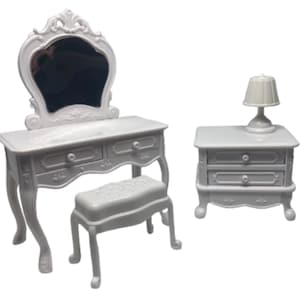 Può includere: Un set da toeletta in miniatura bianco con specchio, due cassetti e uno sgabello abbinato. È inclusa anche una piccola comodino bianco con due cassetti e una lampada. Il set è realizzato in plastica e ha un design classico.