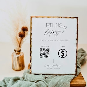 Puede incluir: Un cartel blanco con marco dorado y el texto "Feeling Tipsy? Leave a tip for your bartender."  El cartel tiene un código QR y un icono de signo de dólar para propinas en efectivo. El cartel también incluye el texto "Sally and Anthony, November 10th 20XX".