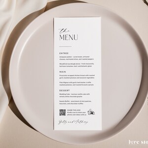 May include: A white wedding menu card with black text. The menu includes starters, main courses, and desserts. The card also includes a QR code and the text "Share the Love" with a camera icon.
