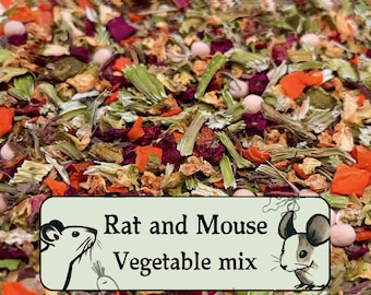 May include: A close-up of a mix of dried vegetables and herbs for rats and mice. The mix includes carrots, beet, and other dried greens. The text "Rat and Mouse Vegetable mix" is printed on a white label.