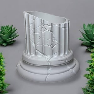 May include: A white, weathered, ceramic column with a cracked surface. The column is a decorative piece with a rounded base.