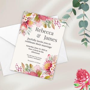 May include: Wedding invitation featuring floral watercolor designs in pink, red, and green. The invitation includes the names "Rebecca & James" and event details. A white envelope is visible behind the invitation.