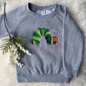 Maglione ricamato per bambini/neonati Hungry Caterpillar - Perfetto per la settimana del libro