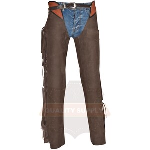 May include: Brown leather chaps with fringe detailing along the outer seams. The chaps are worn over blue denim jeans and a brown and black belt with a silver buckle. A pocket is visible on the right leg.