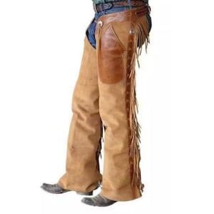 Può includere: Chaps in pelle marrone con dettagli a frangia. I chaps hanno una texture simile al camoscio e una toppa in pelle sul retro.