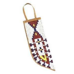 Puede incluir: Una funda de cuchillo de cuentas blancas, rojas, azules y amarillas con una solapa de cuero marrón.
