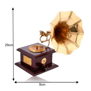 May include: A vintage-style gramophone with a polished brass horn and a dark wood base. The gramophone is 29 cm tall and 9 cm wide. It features a crank handle and a decorative brass plate on the front. The horn is a bright gold color.