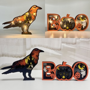 Könnte beinhalten: Zwei hölzerne Halloween-Dekorationen. Eine ist ein schwarzer Rabe mit einer gruseligen Szene, die in seinen Körper geschnitzt ist. Die andere ist ein "BOO"-Schild mit einem Kürbis und Geistern, die hineingeschnitzt sind.