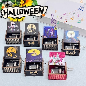 May include: A collection of small, wooden music boxes with various illustrations from "The Nightmare Before Christmas" and other holiday themes. Each box has a crank and a decorative lid.