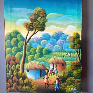 May include: A colourful painting depicting a rural African village scene with thatched-roof huts, green trees, and people working in the fields. The sky is blue with white clouds. The painting is signed "Preve" in the lower right corner.