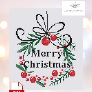 May include: A cross-stitch design featuring a Christmas wreath with the words "Merry Christmas" in the center. The wreath is adorned with red berries and green leaves. The design includes a PDF icon and the text "JULIJA SUPOVA".