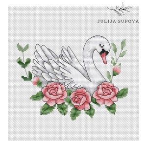 Pode incluir: Cisne branco com rosas cor-de-rosa e folhas verdes. O cisne está rodeado de flores e folhas. A imagem é em estilo ponto cruz.