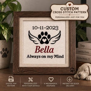 May include: A square wooden frame containing a cross stitch pattern on light fabric. The design features the date 10-11-2023, a black paw print with wings, the name Bella in red, and the text Always on my Mind in black lettering.