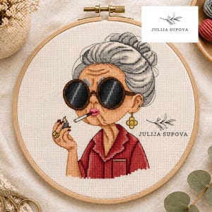 Puede incluir: Patrón de punto de cruz que presenta una caricatura de una mujer mayor con gafas de sol, un cigarrillo y un encendedor. El diseño está en un bastidor de bordado de madera. También se ve el texto "JULIJA SUPOVA" y "Cross Stitch Pattern".