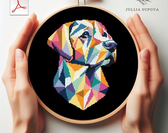 May include: A colorful geometric cross-stitch pattern of a dog's head in a black embroidery hoop. The dog is a Labrador Retriever with a rainbow color scheme.