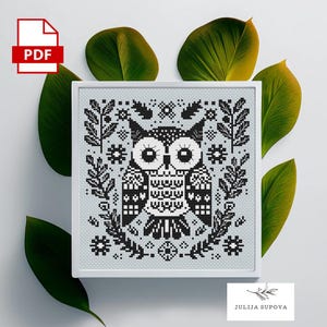 May include: Black and white cross-stitch pattern featuring an owl with floral accents. The pattern is framed in a white frame.