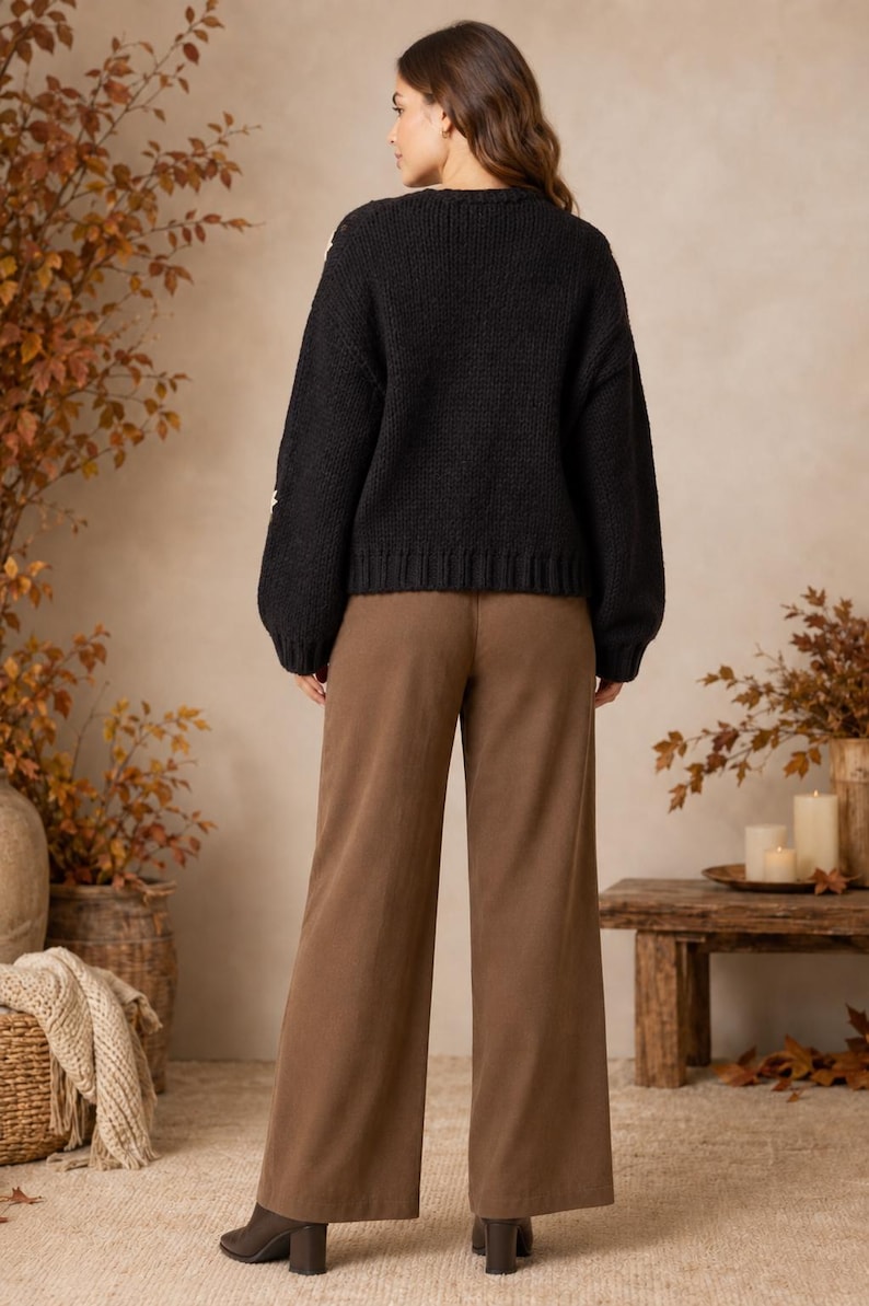 May include: A black long-sleeved knit sweater with a ribbed crew neckline and hem, paired with solid brown wide-leg trousers. The sweater features a textured knit pattern and the trousers have a straight, loose fit reaching the ankles.