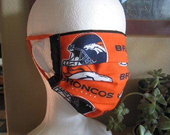 Denver Broncos face mask. Orange NFL licensed fabric. Black and white logos. Pleated style. Black lining. Orange loops. For adults.