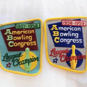 Puede incluir: Dos parches bordados para los campeones de bolos de la liga. Los parches son azules, amarillos, rojos y blancos con el texto "American Bowling Congress" y "League Champion". Un parche es para 1957-1958 y el otro para 1958-1959.