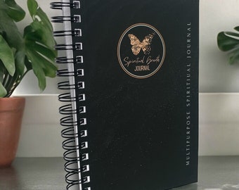 May include: Black spiral bound journal with a gold butterfly and the text "Spiritual Growth Journal" in a circle. The journal is labeled "Multipurpose Spiritual Journal".