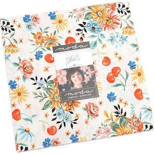 May include: A white fabric with a floral pattern featuring red cherries, yellow sunflowers, blue and pink flowers. The fabric has the text "moda" printed on it.