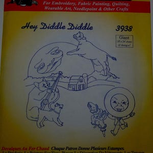 May include: Aunt Martha's Hot Iron Transfers sheet with the text "Hey Diddle Diddle" and a cartoon illustration of a cow jumping over the moon, a cat playing a fiddle, and other nursery rhyme characters. The sheet measures 18 x 24 inches.
