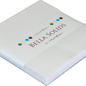 May include: A stack of white fabric squares with a label that reads "moda Bella Solids by moda" with colorful dots.