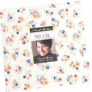 May include: White fabric with a small floral print in shades of pink, blue, yellow, and orange. The fabric features a small white polka dot pattern. The fabric is labeled "Cali & Co. by Corey Yoder of Coriander Quilts" and "moda fabrics + supplies".