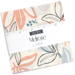 May include: A white fabric square with a pink, blue, and black floral pattern. The fabric is labeled "Melrose by Studio E" and "Moda Fabrics & Supplies".