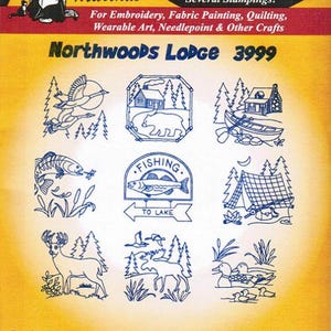 May include: A sheet of iron-on transfer designs for crafts. The designs feature a cabin, a bear, a boat, a fish, a tent, a deer, a moose, and ducks. The sheet is yellow with blue text that reads "Hot Iron Transfers" and "Northwoods Lodge 3999".