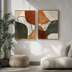 Könnte beinhalten: Zwei abstrakte Kunstdrucke mit minimalistischem Design, die organische Formen in Braun-, Grün- und Weißtönen zeigen. Die Drucke sind in einem hellen Holzrahmen gerahmt.