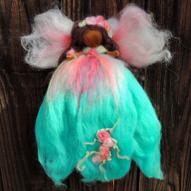 Needle felted World Fairy Waldorf inspired By Rebecca Varon pinks and she has dark skin and brwon hair with blues