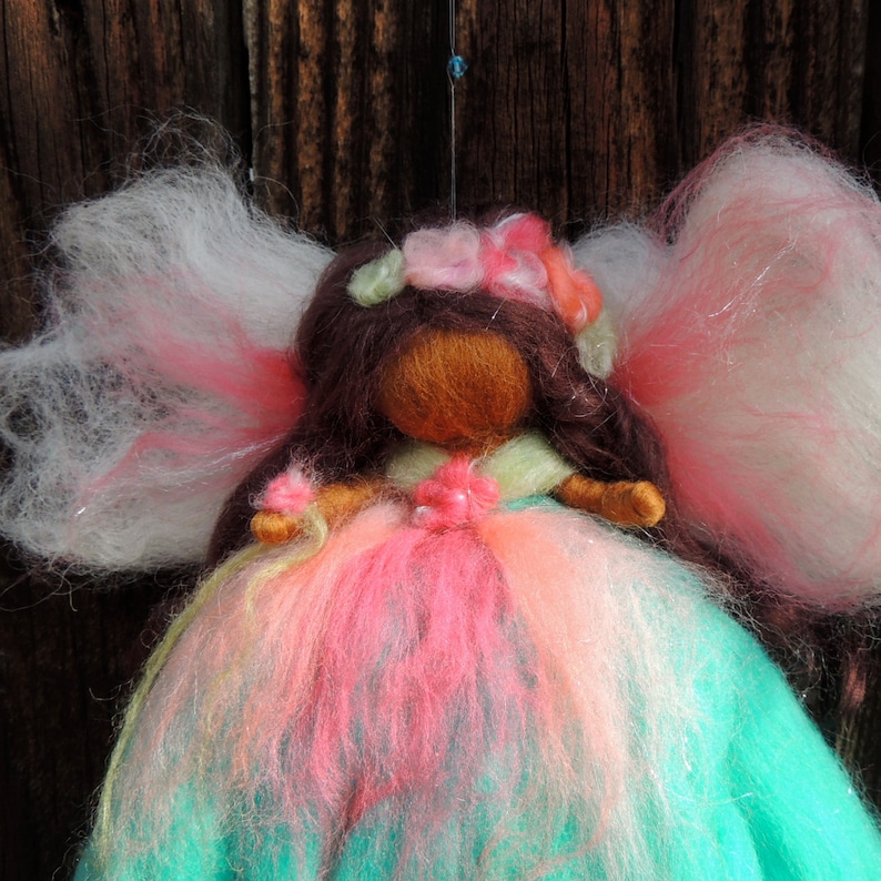 Needle felted World Fairy Waldorf inspired By Rebecca Varon pinks and she has dark skin and brwon hair with blues