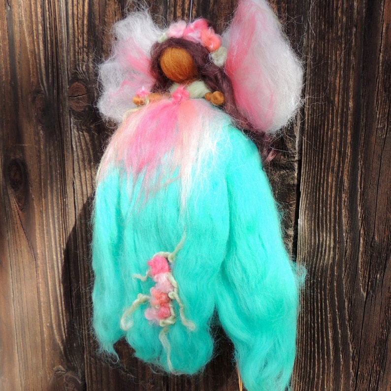 Needle felted World Fairy Waldorf inspired By Rebecca Varon pinks and she has dark skin and brwon hair with blues