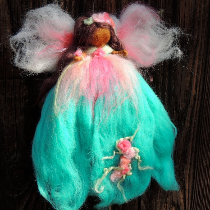 Needle felted World Fairy Waldorf inspired By Rebecca Varon pinks and she has dark skin and brwon hair with blues