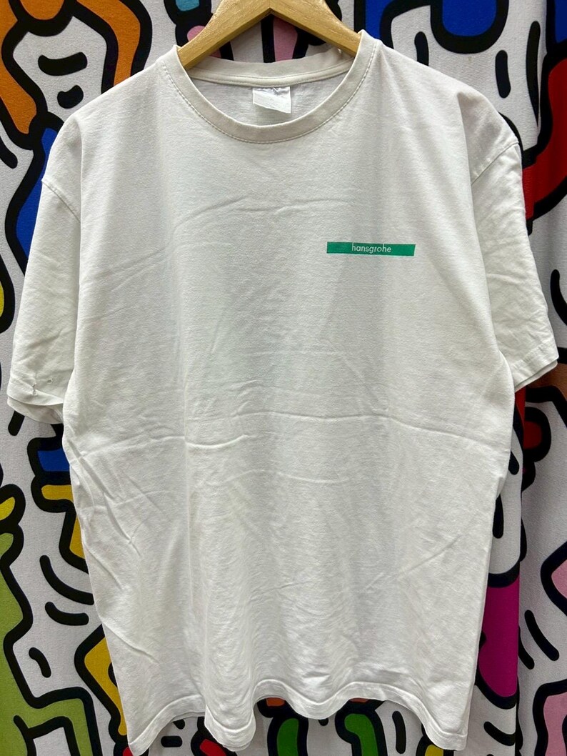 May include: White t-shirt with a green rectangular logo that says "hansgrohe" on it.