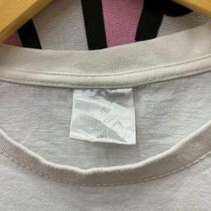 May include: White t-shirt with a white tag that says "EUROSIZE" and "SIZE 170/82" with a size "XL" printed on it.