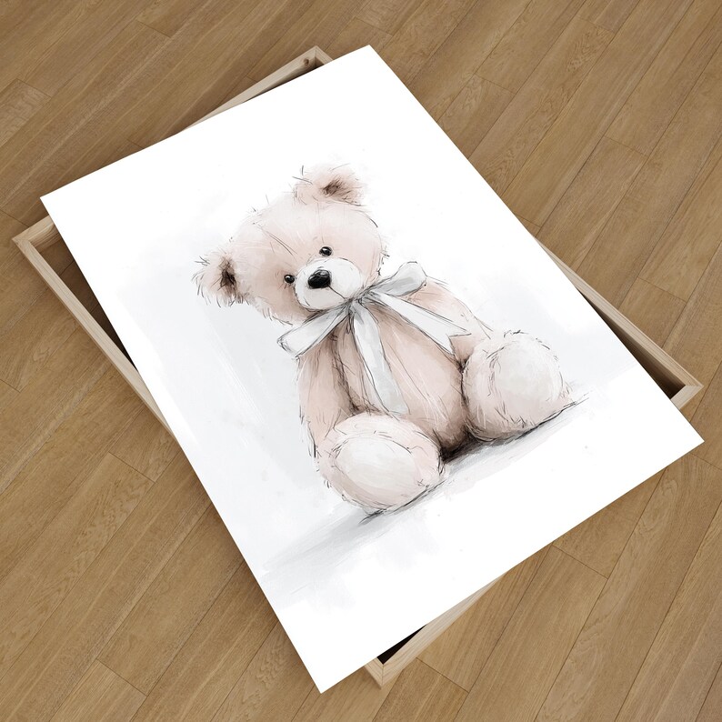 May include: A framed print of a watercolour illustration of a teddy bear. The bear is light pink with a white bow and black eyes. The artwork is set against a white background.