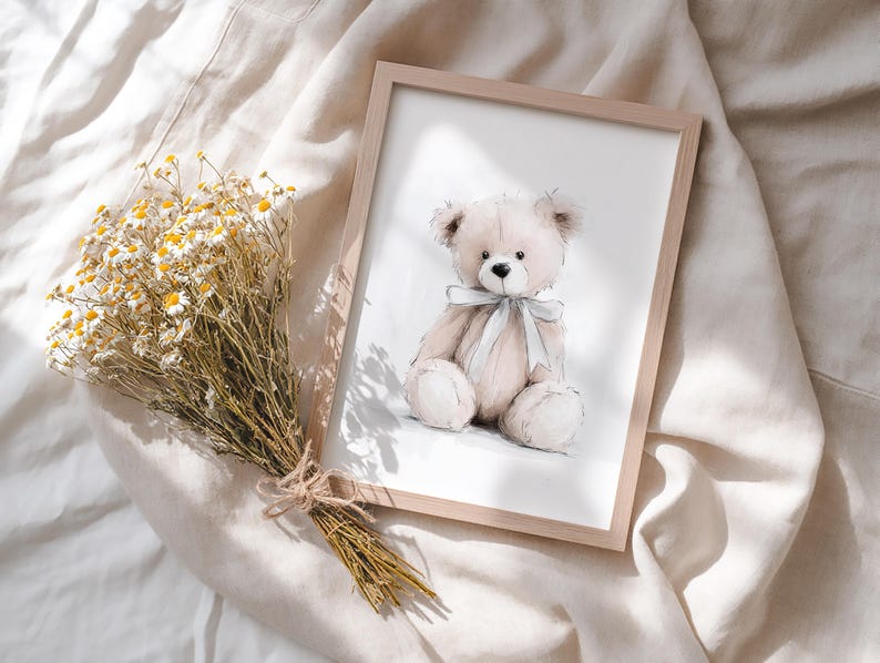 May include: A framed print of a watercolour illustration of a beige teddy bear with a light blue ribbon. The bear is sitting, with a soft, plush appearance. A bouquet of dried yellow and white flowers is tied with twine, adding a natural touch.